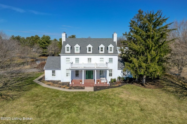 rear view of property with a chimney and a lawn