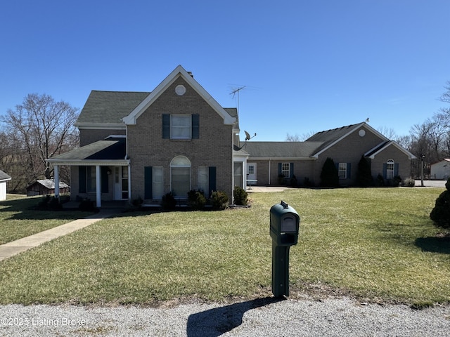 traditional-style home featuring brick siding and a front yard