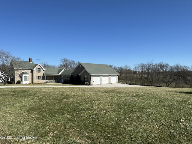 view of front of property with a front lawn, a chimney, and a detached garage