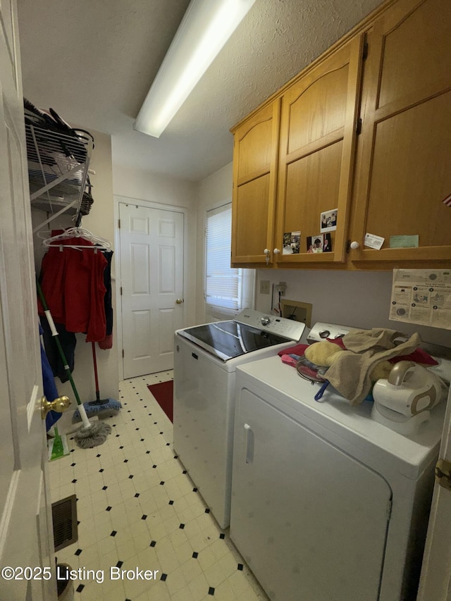 washroom with cabinet space, visible vents, light floors, and independent washer and dryer