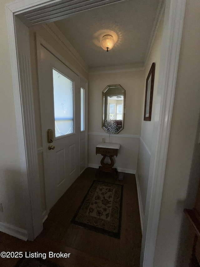 doorway with crown molding and baseboards