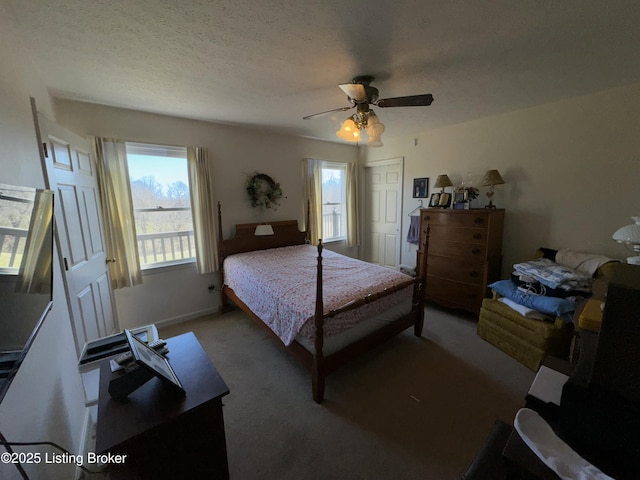 carpeted bedroom featuring a textured ceiling, multiple windows, and a ceiling fan