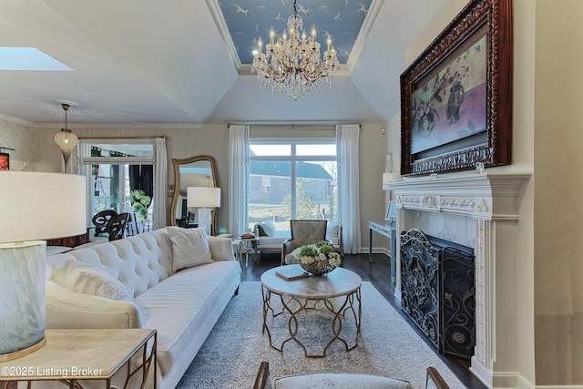 living room with baseboards, wood finished floors, a fireplace, and ornamental molding