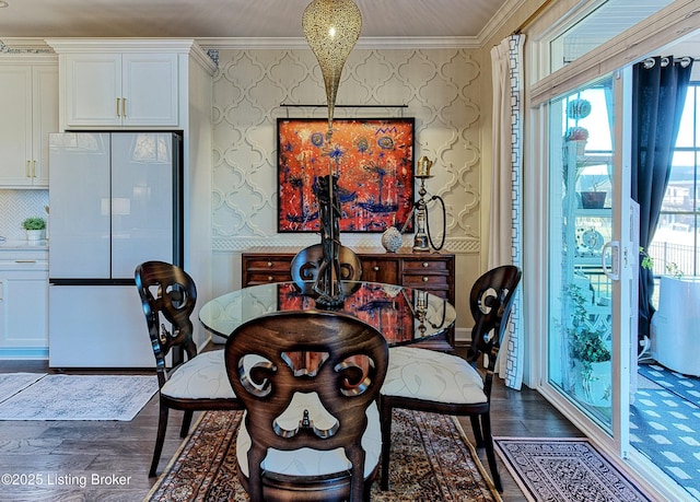 dining space featuring wallpapered walls, dark wood-type flooring, and ornamental molding