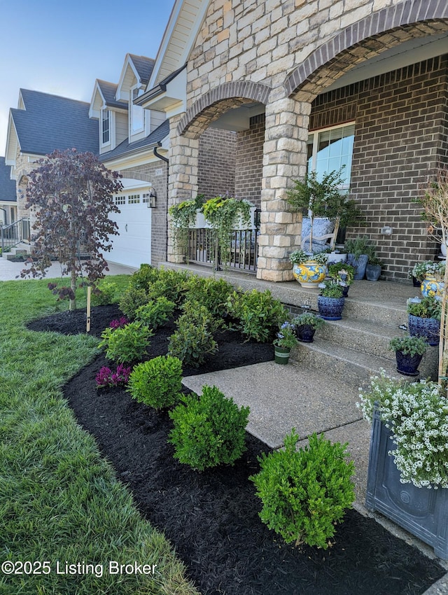 exterior space with brick siding, stone siding, and an attached garage