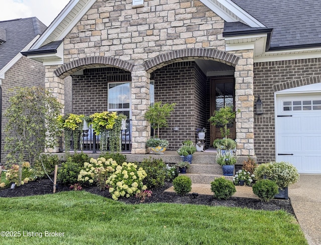 property entrance with a garage, stone siding, brick siding, and roof with shingles