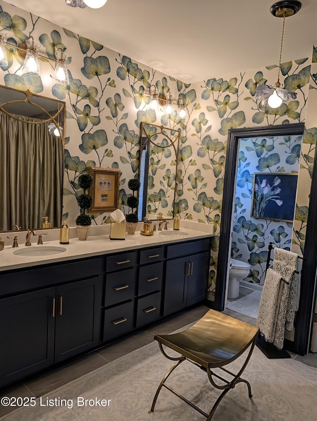 bathroom with wallpapered walls, tile patterned flooring, and a sink