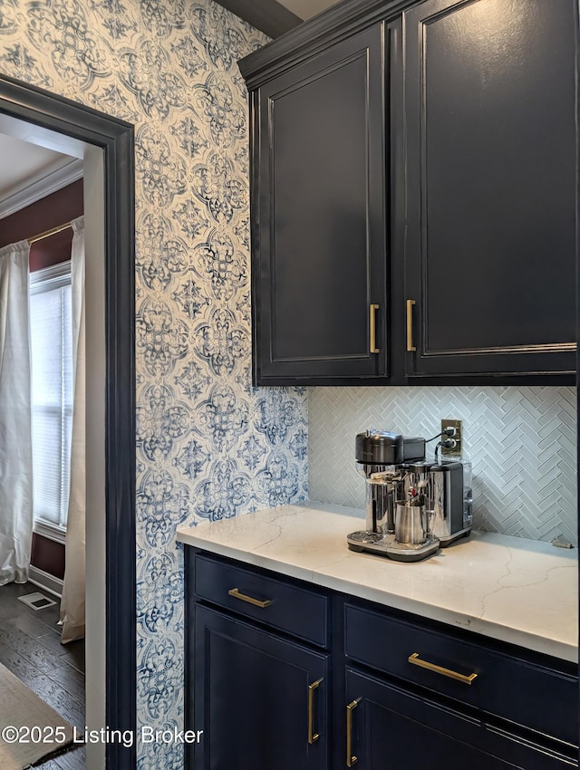 bar with wallpapered walls and tasteful backsplash