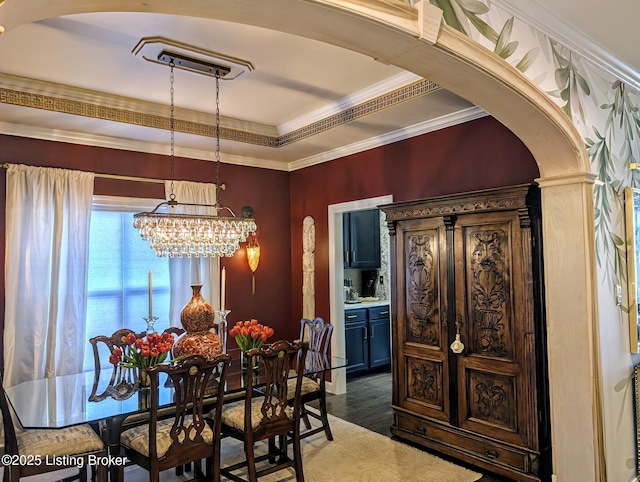 dining room with arched walkways, dark wood-style floors, crown molding, and an inviting chandelier