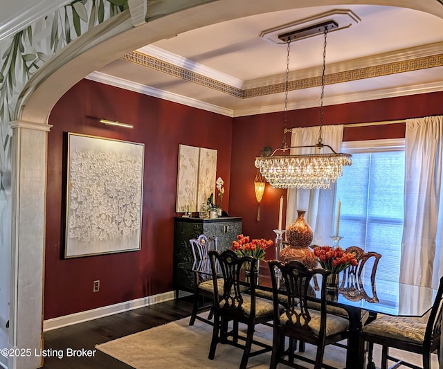 dining space featuring wood finished floors, baseboards, an inviting chandelier, arched walkways, and crown molding