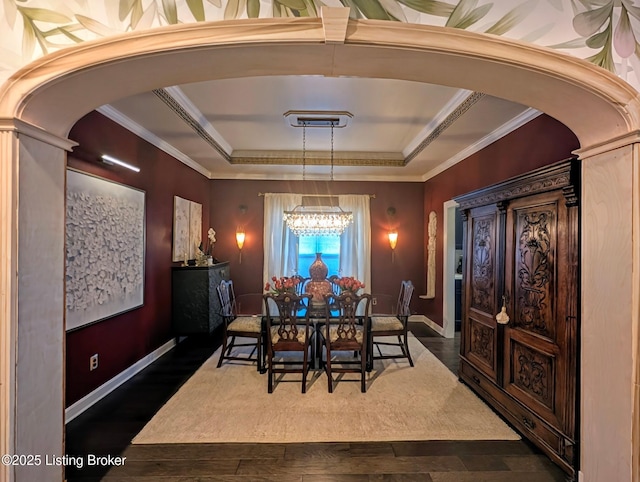 dining space featuring a raised ceiling, arched walkways, dark wood-type flooring, and ornamental molding