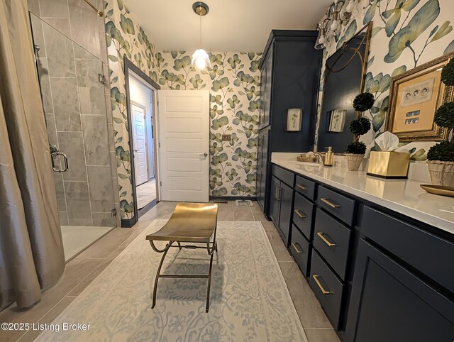 bathroom with tile patterned floors, a shower, wallpapered walls, and vanity