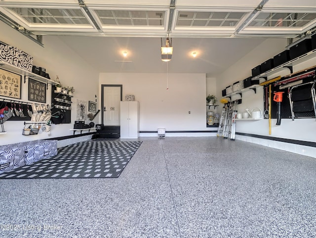 garage featuring a garage door opener and baseboards