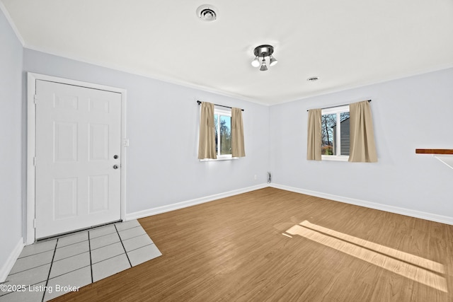 interior space with wood finished floors, visible vents, and baseboards