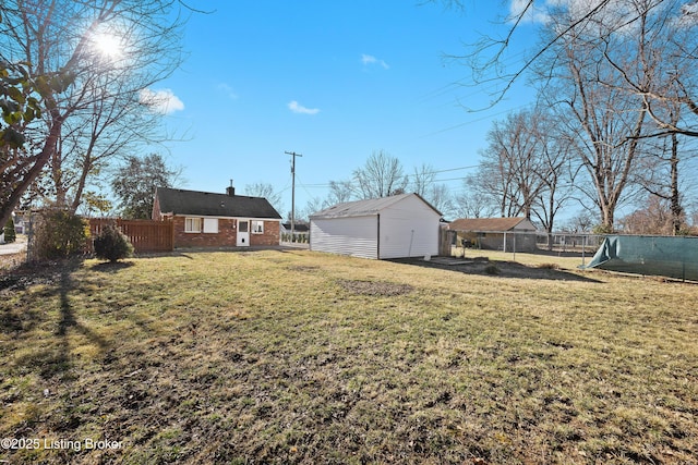 view of yard featuring fence and an outdoor structure