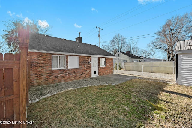 rear view of house featuring brick siding, fence, a patio, and a lawn