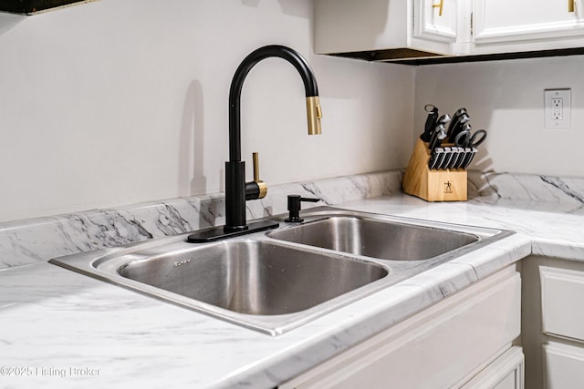 room details featuring light countertops, white cabinetry, and a sink