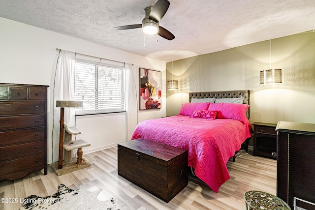 bedroom featuring ceiling fan, a textured ceiling, and wood finished floors