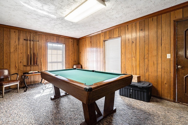 recreation room with billiards, ornamental molding, carpet, a textured ceiling, and wood walls