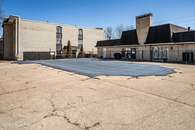 community pool featuring a patio area and fence