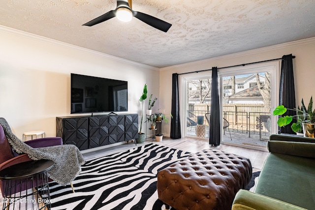 living area featuring a ceiling fan, crown molding, a textured ceiling, and wood finished floors