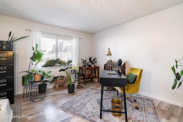 home office featuring a textured ceiling, baseboards, and wood finished floors