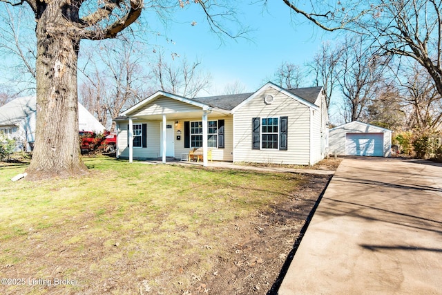 view of front of home with an outbuilding, a detached garage, covered porch, a front yard, and driveway