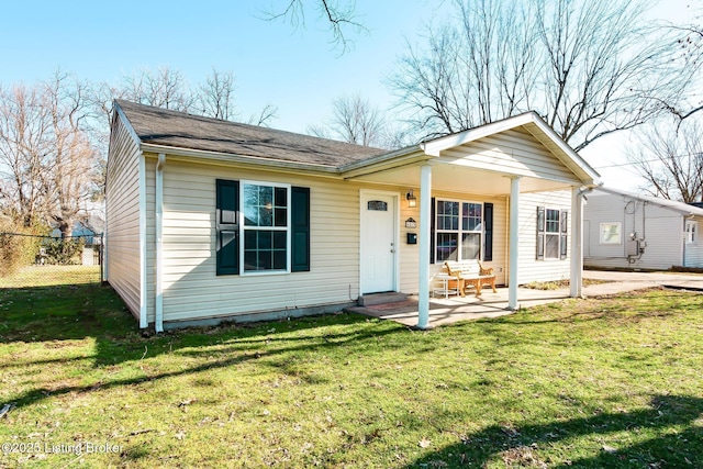 view of front facade with a front lawn, a patio area, and fence