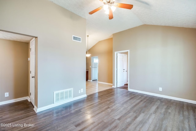 empty room featuring visible vents, baseboards, and wood finished floors