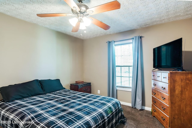 bedroom with a ceiling fan, dark carpet, a textured ceiling, and baseboards