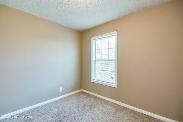 carpeted spare room with baseboards and a textured ceiling