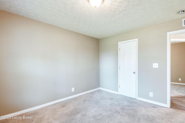 unfurnished bedroom with carpet floors, visible vents, a textured ceiling, and baseboards