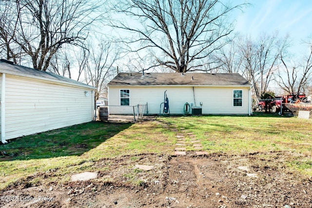 back of house featuring a lawn and fence