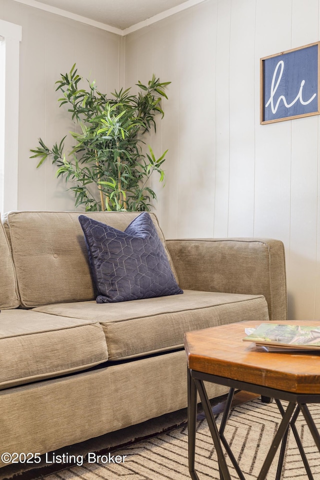 living room featuring crown molding and a decorative wall