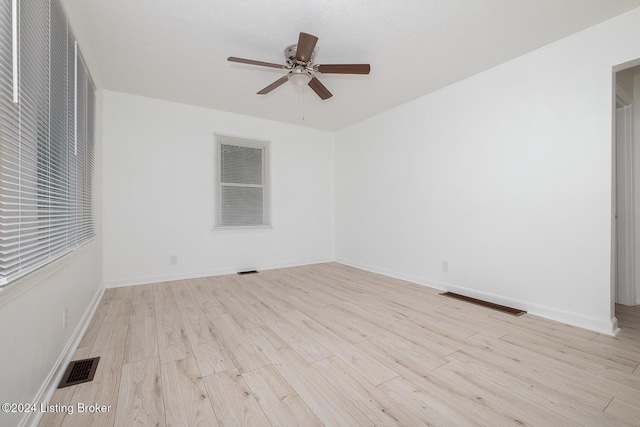 unfurnished room with light wood-style floors, baseboards, and visible vents