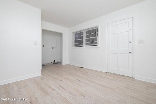 unfurnished room with light wood-style flooring, visible vents, and baseboards