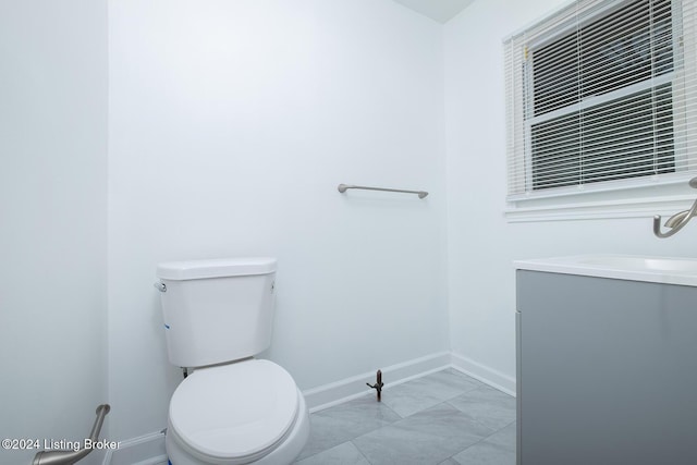 bathroom featuring marble finish floor, baseboards, vanity, and toilet