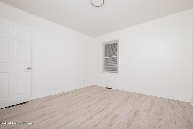 spare room featuring baseboards and wood finished floors