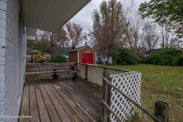 wooden deck with a yard, a storage unit, and an outdoor structure