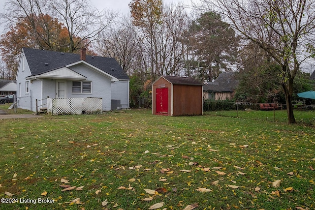 view of yard with a fenced backyard, a storage unit, and an outdoor structure