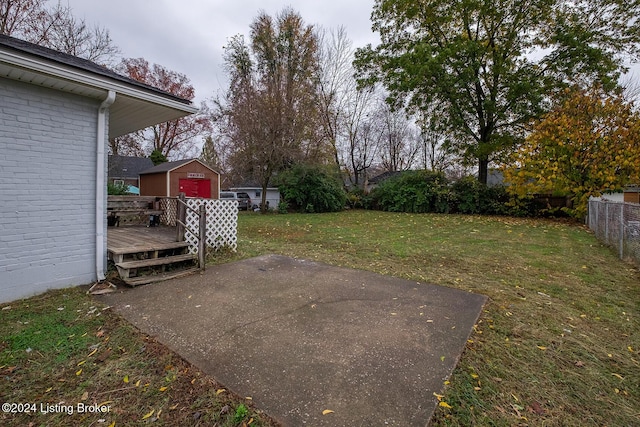 view of yard with a patio area, a wooden deck, and fence