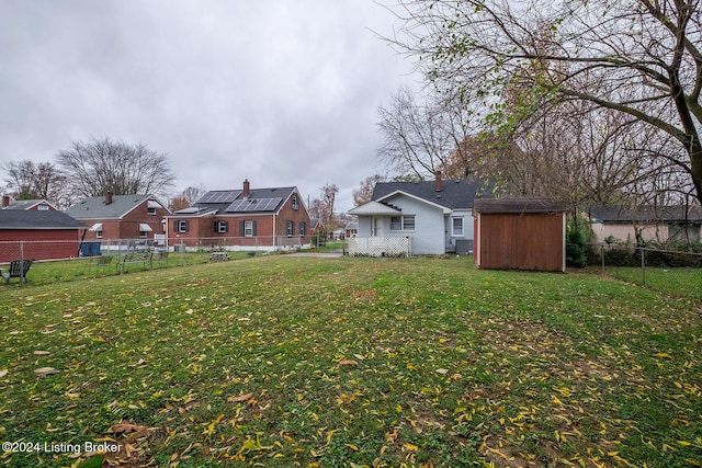 view of yard featuring a storage shed, a fenced backyard, a residential view, and an outdoor structure