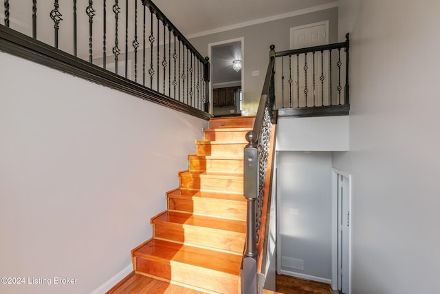 staircase featuring crown molding and baseboards