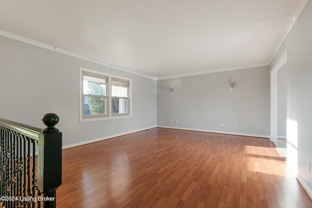 unfurnished room featuring baseboards, ornamental molding, and wood finished floors