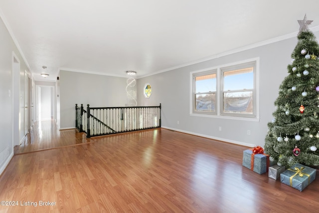 spare room featuring ornamental molding, wood finished floors, and baseboards