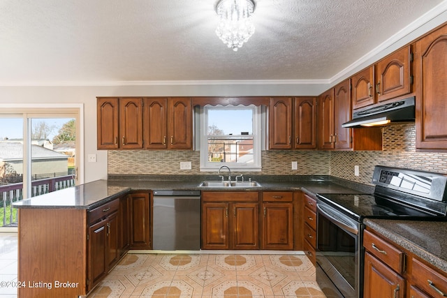 kitchen featuring dark countertops, a peninsula, stainless steel appliances, under cabinet range hood, and a sink