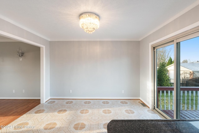 empty room featuring baseboards, a textured ceiling, wood finished floors, and an inviting chandelier