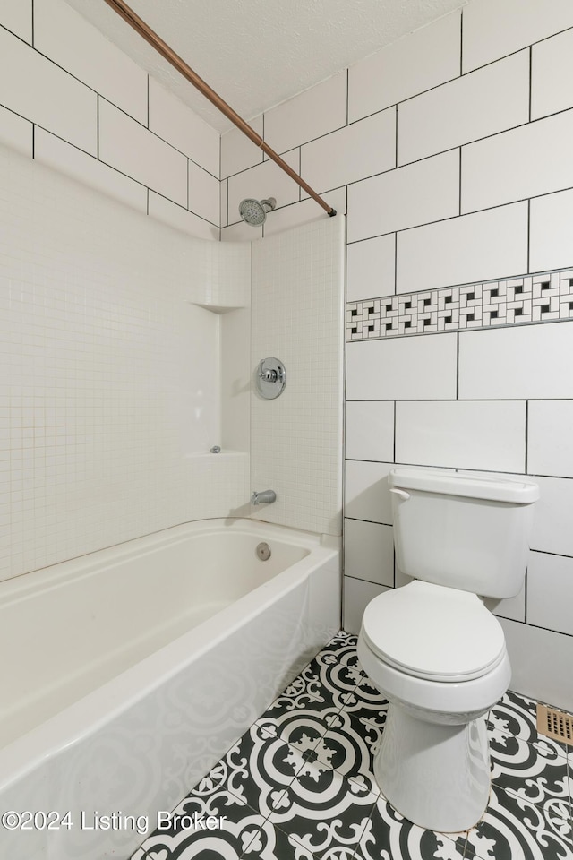 bathroom with toilet, bathtub / shower combination, tile walls, and tile patterned floors