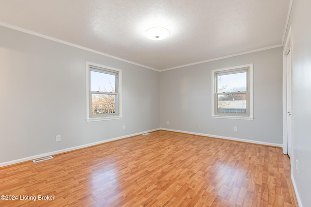 unfurnished room with a healthy amount of sunlight, light wood-style floors, and visible vents