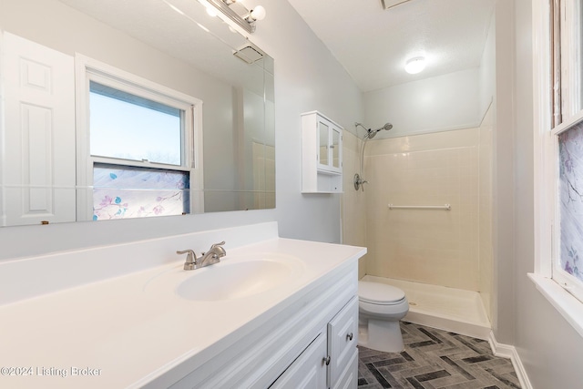 full bath with toilet, a stall shower, baseboards, and vanity